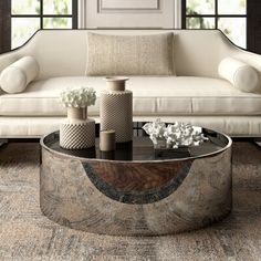 a living room with a couch, table and two vases on the coffee table