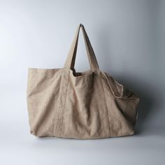 a large beige bag sitting on top of a white table next to a gray wall