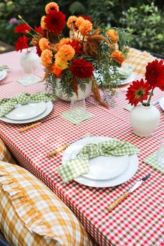 the table is set with flowers and plates