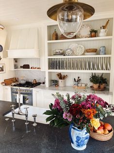 a vase with flowers sitting on top of a kitchen counter