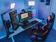 a computer desk with two monitors and a keyboard on it in front of a lamp