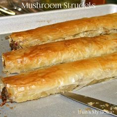 there are two long rolls on the baking pan together, one is filled with meat