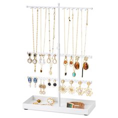 a white jewelry rack with several different necklaces and rings on it's sides