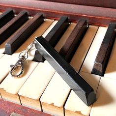 a keychain is sitting on top of an old piano with keys attached to it