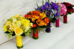 colorful bouquets of flowers lined up on a white couch