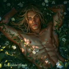 a man laying in the grass with his shirt off and flowers all around him, surrounded by greenery