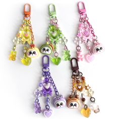 several key chains with charms attached to them on a white surface in various colors and shapes