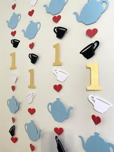 teapots, cups and hearts are hanging on the wall next to each other