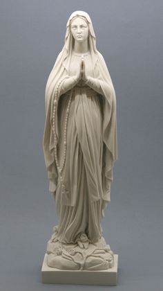 a statue of the virgin mary holding her hands together