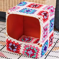 a crocheted box sitting on top of a rug