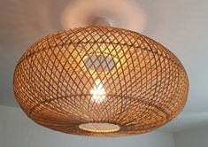 a bamboo light fixture hanging from the ceiling in a room with white walls and flooring