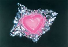 a heart shaped candy in foil on a black background