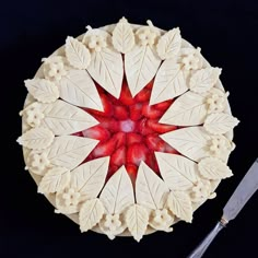 a white plate with red flowers and leaves on it next to a pair of scissors