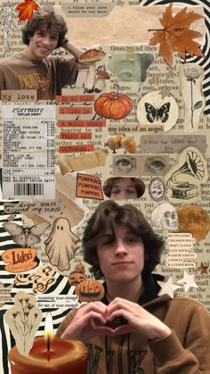 a boy making a heart with his hands while sitting in front of a pumpkin decorated wall