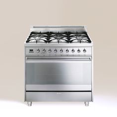 a stainless steel stove with four burners and two oven doors on each side, in front of a gray background