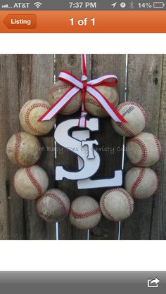 a wreath made out of baseballs with the letter s on it and a bow