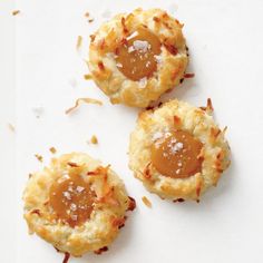 three biscuits with caramel sauce on them are sitting on a white surface and sprinkled with coarsed sugar