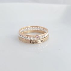 Mother's Day Gift | -the Isabelle- Personalized stackable ring set, engraved with a name, date, or special word.  Metal: .925 sterling silver, and 14k gold filled Dimensions: name ring is 2mm tall on average, but our rings are handmade so variations will occur. Birthstone is 2mm on a 1mm band. Font: lowercase typewriter Unsure what size you need? We highly recommend using our ring sizer for an accurate fit. Some people find that sizing up when stacking 3 or more rings is more comfortable. https: Fine Jewelry Adjustable Stackable Rings For Anniversary, Adjustable White Jewelry With Engraving Option, Adjustable Stackable Jewelry For Anniversary, White Engraved Ring For Promise With Name, White Engraved Ring With Name For Anniversary, Custom Name Rose Gold Ring Jewelry, Customizable Gold Birthstone Ring For Weddings, Custom Name Rose Gold Ring, Adjustable Engraved Rose Gold Ring For Anniversary