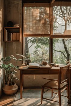 a wooden table sitting in front of a window next to a potted plant and bookshelf