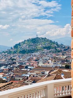 a view of a city from the top of a building with mountains in the background