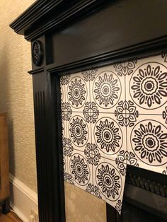 the fireplace is decorated with black and white tiles