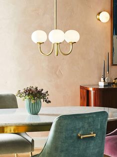 a dining room table with two chairs and a vase on the table in front of it