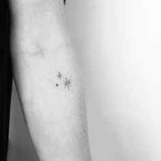 a black and white photo of a person's arm with three stars on it