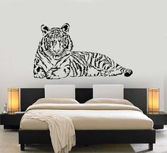 a tiger wall decal sitting on top of a bed