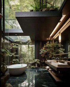 a bathroom with a large bathtub and two sinks in front of the tub is surrounded by greenery