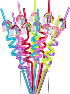 a vase filled with lots of colorful plastic straws and rainbow colored streamers in it