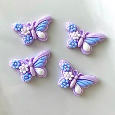 three decorated cookies with blue and white butterflies