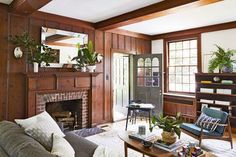 a living room filled with furniture and a fire place next to a fireplace covered in potted plants