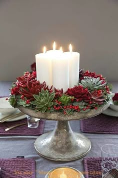 candles are lit on top of a silver cake plate