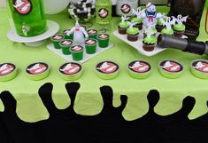 a green table topped with cupcakes and candy