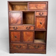 an old wooden bookcase with drawers and knobs on the front, against a white background