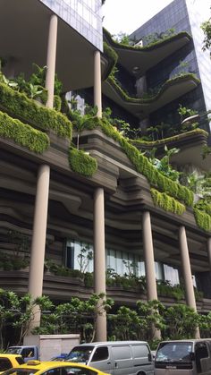 cars parked in front of a building with plants growing on it