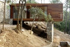 a house built into the side of a hill with trees growing out of it's sides