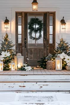 the front porch is decorated for christmas with wreaths and lanterns on it, along with candles