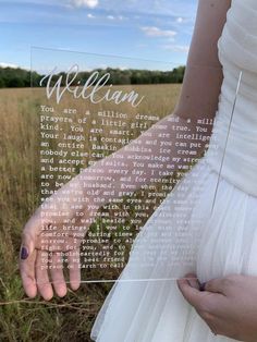 a woman in a white dress holding onto a glass plaque with the words william written on it