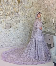 a woman standing in front of a chandelier wearing a wedding dress and veil