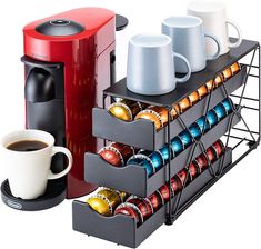 a coffee maker and two mugs on a rack next to a cup of coffee