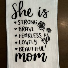 a tea towel with the words she is strong brave fearless lovely beautiful mom