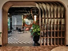 an open door leading into a room with chairs and tables in it, along with a potted plant on the floor