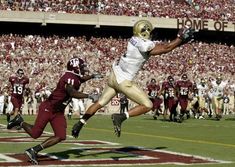 a football player jumping into the air to catch a ball