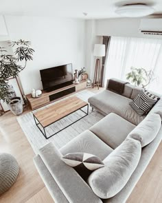 a living room filled with furniture and a flat screen tv on top of a wooden table