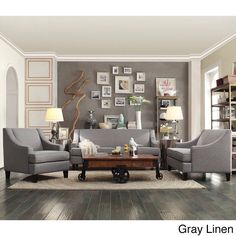 a living room filled with gray furniture and pictures on the wall above it's windows