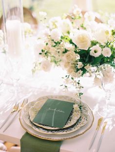 a table set with plates, napkins and flowers