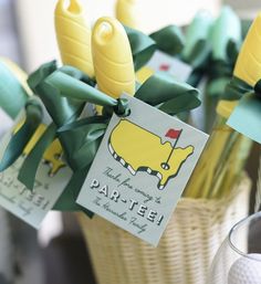 some yellow and green golf tees in a basket with tags attached to the stems