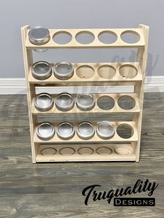 a wooden shelf filled with metal pans on top of a hard wood floor