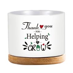 a white mug with the words thank you for helping grow on it and a wooden lid